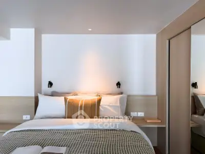 Modern bedroom with cozy bedding and stylish decor in a contemporary apartment.