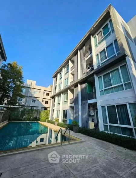 Modern apartment building with pool and clear blue sky