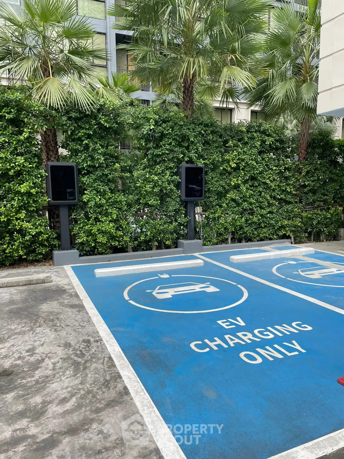 Modern EV charging station in a lush green parking area, perfect for eco-friendly living.