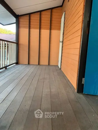 Charming wooden balcony with warm-toned siding and railing, perfect for relaxation.