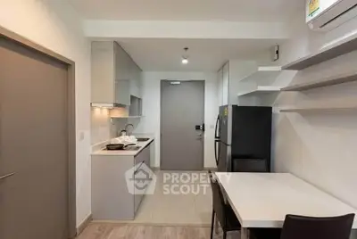 Modern kitchen with sleek cabinetry and dining area in a contemporary apartment.
