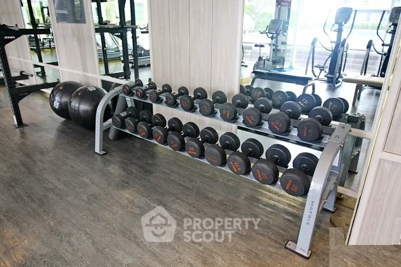 Modern gym with dumbbells and exercise equipment in a sleek fitness center.