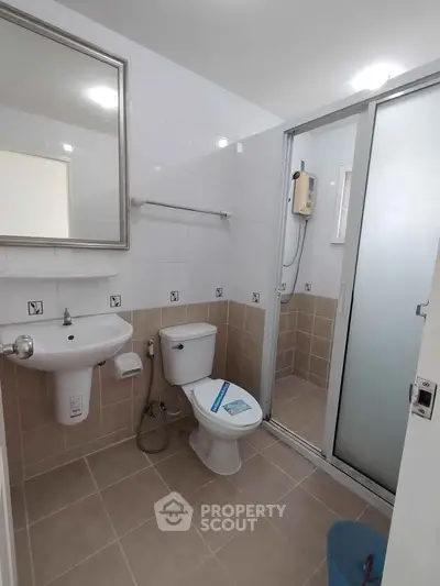 Modern bathroom with shower enclosure and sleek fixtures in a contemporary apartment.