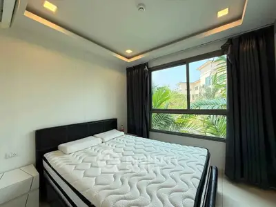 Spacious bedroom with large window and modern decor, perfect for relaxation.