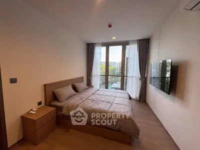 Modern bedroom with large window and stylish decor in a contemporary apartment.