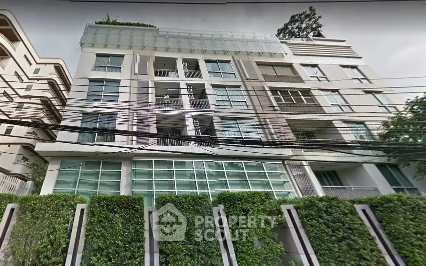 Modern apartment building with lush greenery and large windows