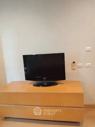 Modern living room with sleek TV setup on wooden cabinet, perfect for cozy entertainment.