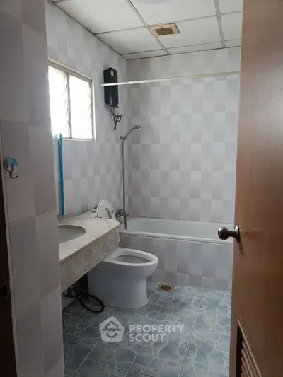 Modern bathroom with bathtub and tiled flooring in a real estate property