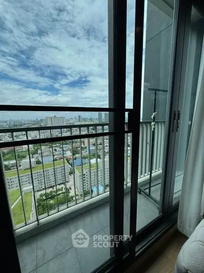 Stunning high-rise balcony view with expansive cityscape and clear blue sky.