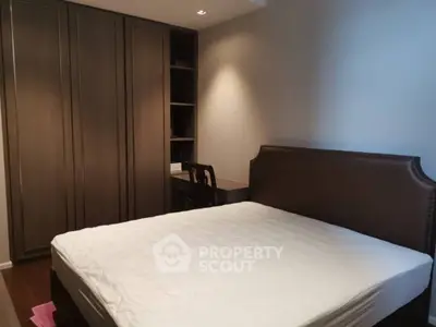 Cozy bedroom with elegant wooden wardrobe and comfortable bed in modern apartment.