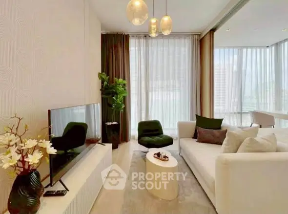 Modern living room with elegant decor and large windows offering natural light.