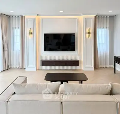 Elegant living room with modern decor and wall-mounted TV, perfect for relaxation and entertainment.