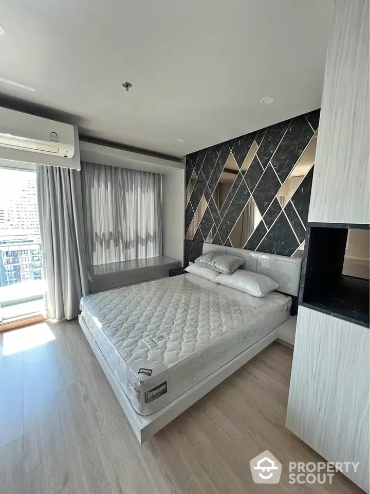 Modern bedroom with stylish geometric accent wall and large window view