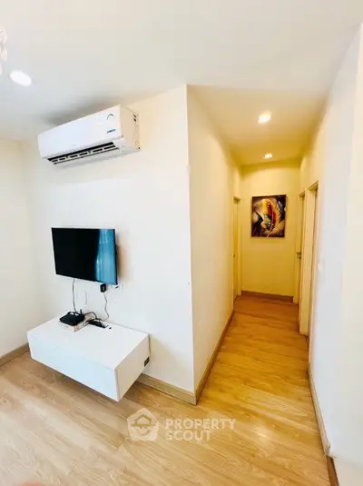 Modern living room with wall-mounted TV and air conditioning in a cozy apartment