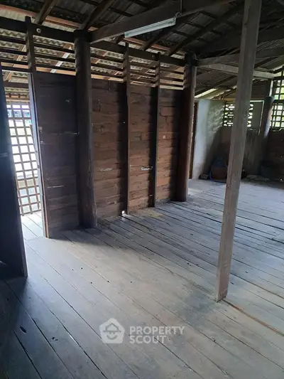Rustic wooden interior with open layout and natural light, perfect for creative renovation.