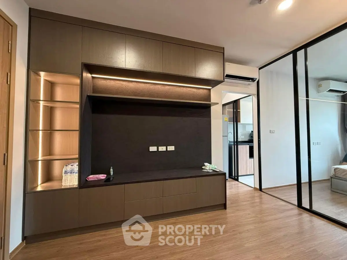 Modern living room with sleek built-in shelving and mirrored closet doors.