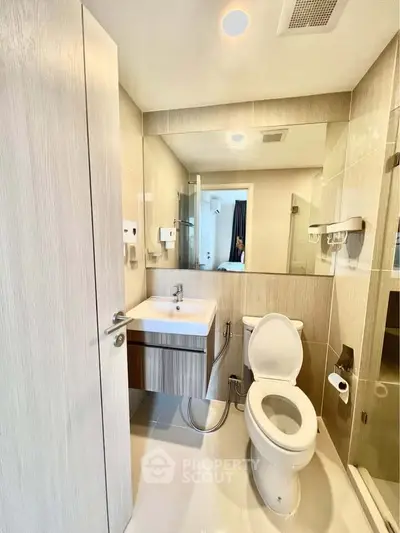 Modern bathroom with sleek fixtures and neutral tones, featuring a compact design ideal for urban living.