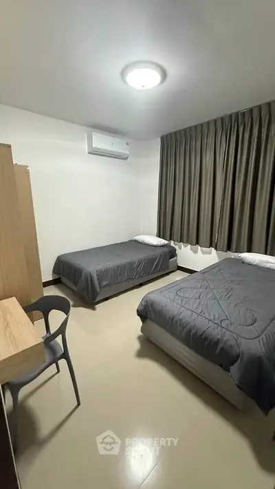 Modern bedroom with twin beds and sleek furnishings in a cozy apartment.