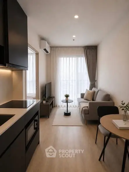 Modern living room with cozy sofa, sleek kitchen, and natural light in stylish apartment.