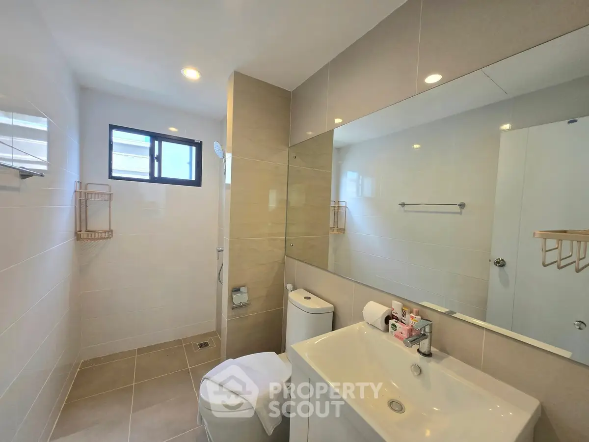 Modern bathroom with sleek fixtures and large mirror in a bright apartment.