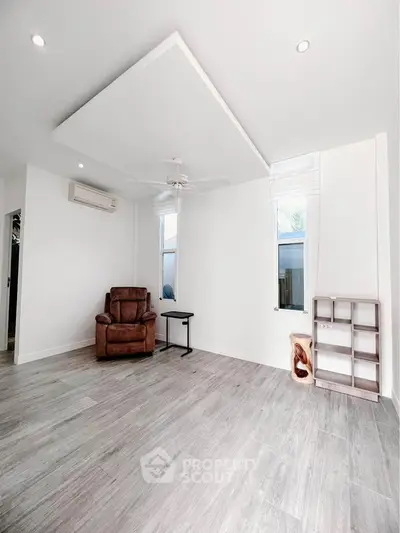 Spacious minimalist living room with modern flooring and natural light