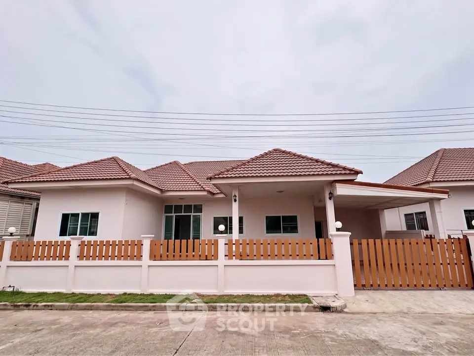 Charming single-story house with tiled roof and fenced yard in a serene neighborhood.