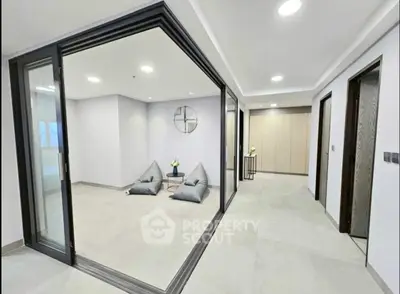 Modern minimalist interior with sliding glass doors and cozy seating area.