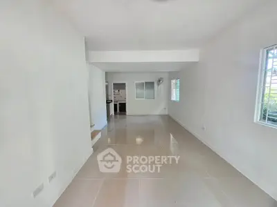 Spacious and bright living room with modern tile flooring and large windows for natural light.