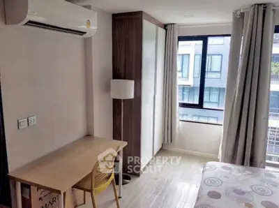 Modern bedroom with study area and large window in urban apartment