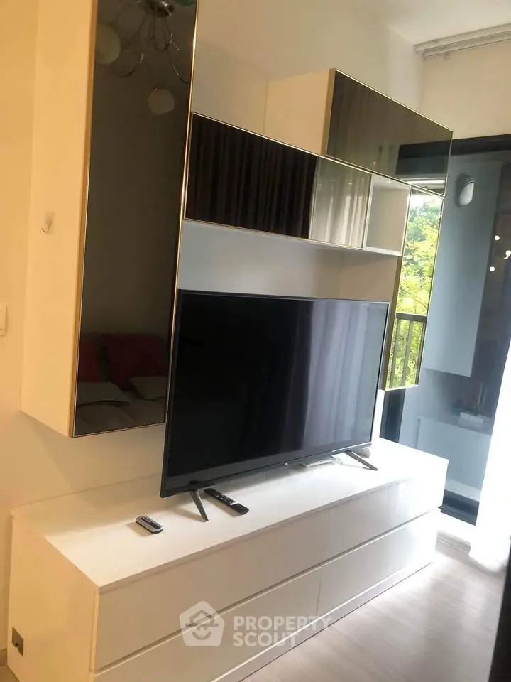 Modern living room with sleek TV unit and balcony view, perfect for urban living.