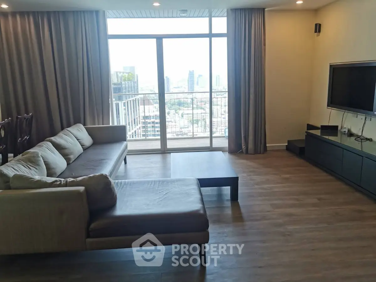 Spacious living room with city view and modern furnishings in high-rise apartment