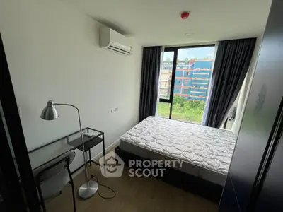 Modern bedroom with large window and study desk in urban apartment
