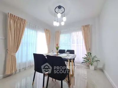 Bright dining area with modern chandelier and elegant curtains