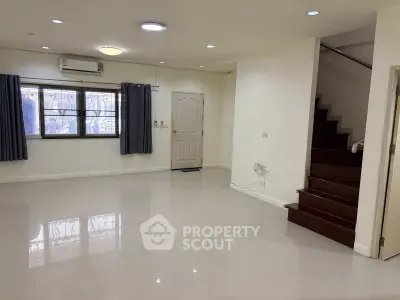 Spacious unfurnished living room with staircase and large windows in modern home