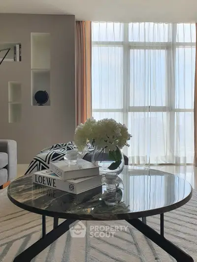 Elegant living room with modern decor and large windows offering natural light.