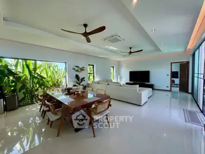 Spacious modern living room with elegant dining area and lush garden view, perfect for luxury living.