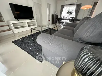 Modern living room with sleek furniture and large TV, perfect for relaxation and entertainment.