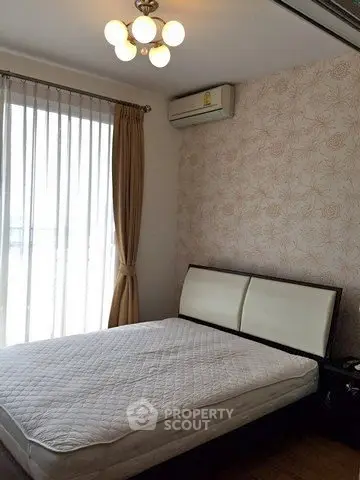Cozy bedroom with elegant lighting and air conditioning, featuring a large window with curtains.