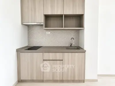 Modern compact kitchen with sleek cabinetry and integrated appliances in a minimalist design.