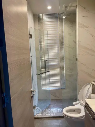 Modern bathroom with glass shower and marble walls