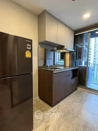 Modern kitchen with sleek cabinets and stainless steel appliances in a high-rise apartment.