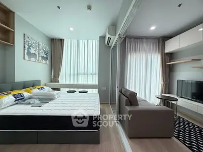 Modern studio apartment with open layout, featuring a cozy living area and a comfortable bed.