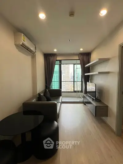 Modern living room with city view, featuring sleek furniture and natural light.