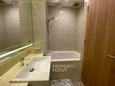 Modern bathroom with sleek fixtures and bathtub in contemporary apartment.