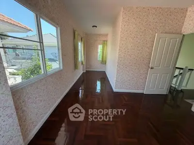 Charming hallway with polished wooden floors and floral wallpaper, offering a cozy and inviting atmosphere.