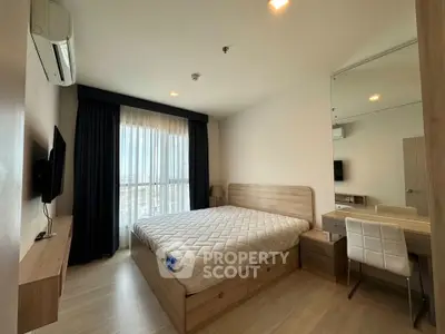 Modern bedroom with large window and stylish furnishings in a high-rise apartment.