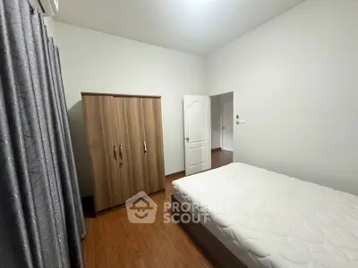 Spacious bedroom with wooden wardrobe and comfortable bed