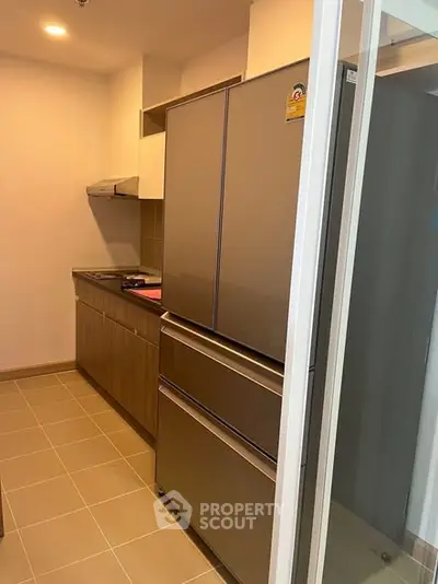 Modern kitchen with sleek appliances and ample storage space in a contemporary apartment.