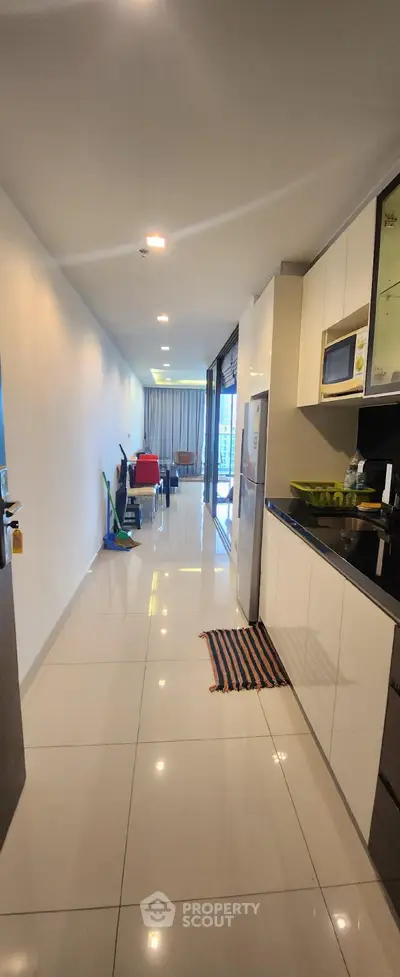 Modern open-layout kitchen with sleek cabinetry and dining area in a spacious apartment