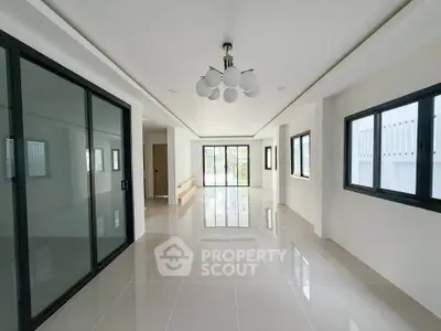 Spacious modern living room with sleek tile flooring and large windows for natural light.